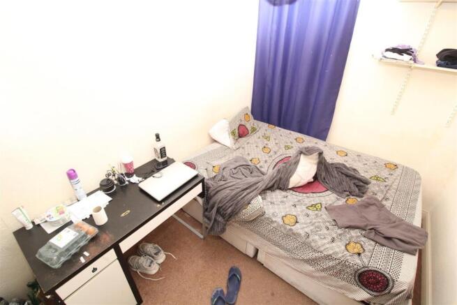 Bright bedroom with desk and built-in shelving...