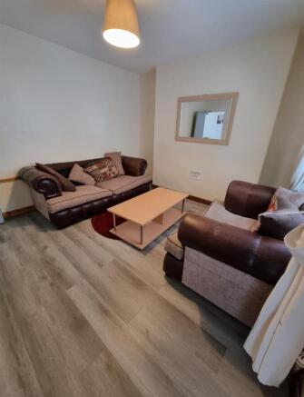 Cosy lounge with wood flooring and plush sofas...