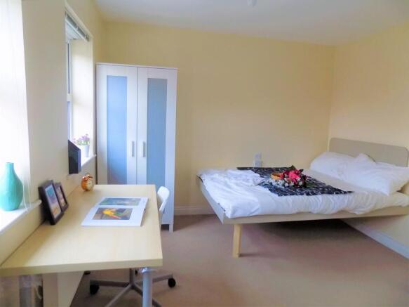 A bright and tidy double bedroom featuring a co...