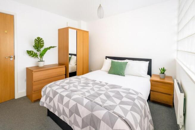 A bright and inviting double bedroom featuring ...