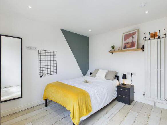A bright and stylish double bedroom featuring m...