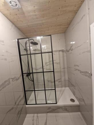 Contemporary tiled bathroom with a framed glass...