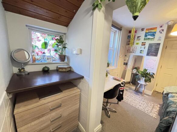 Bright, neatly arranged bedroom corner with a s...