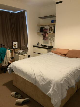 A cozy master bedroom featuring a neatly made b...