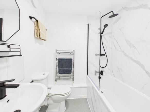 Bright modern bathroom with a white suite, marb...