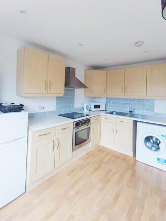 Bright fitted kitchen with light wood cabinetry...