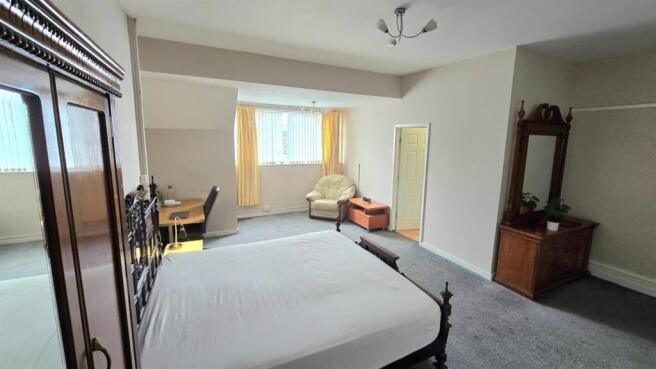 Spacious master bedroom with double bed and des...