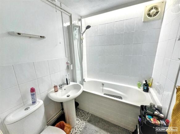 Bright bathroom with combined bath and shower...