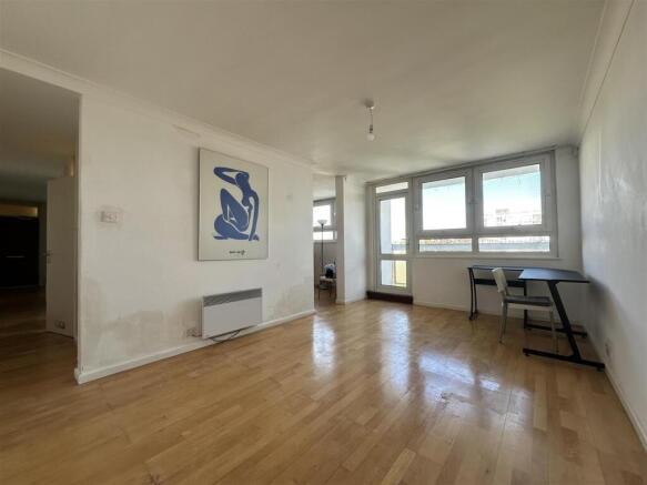 Bright living room with large windows, wood flo...