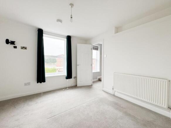 Bright, neutral double bedroom with large sash ...