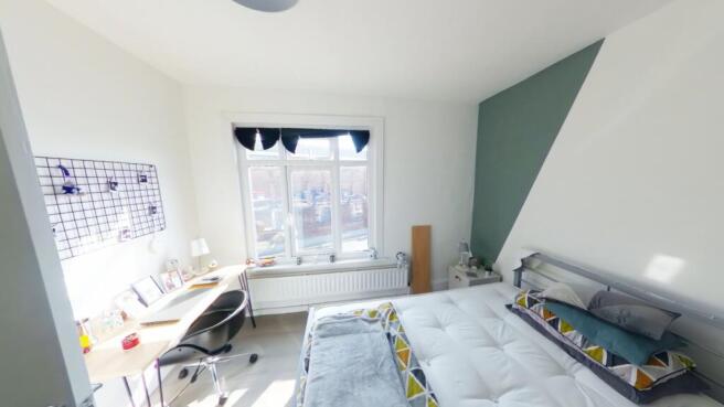 A spacious and bright double bedroom featuring ...