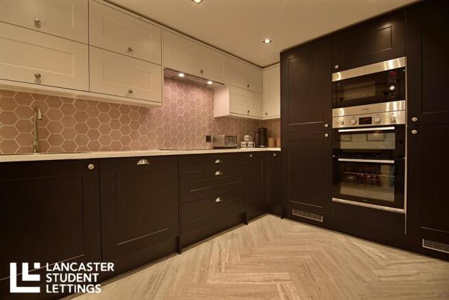 Modern kitchen with sleek dark units and tiling...