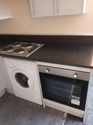 Modern kitchen with integrated oven and laundry...