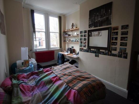 A cozy bedroom featuring a neatly made bed with...