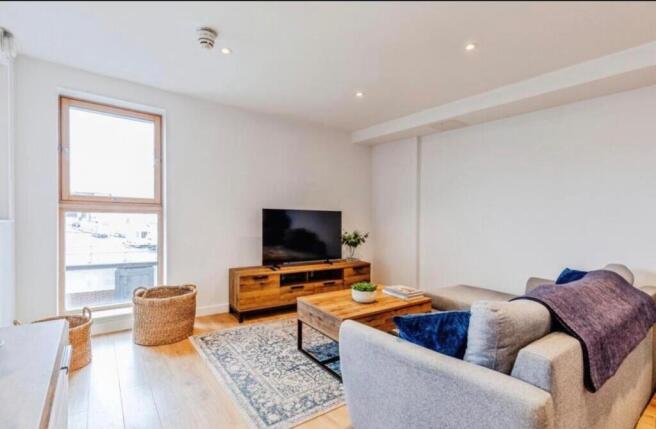 Bright, modern living room with a large window,...