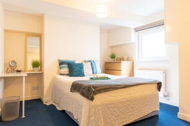 Bright, neatly styled double bedroom with a com...