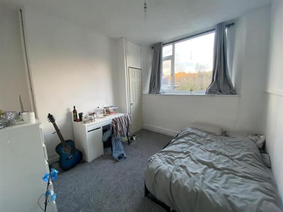 Bright bedroom with large window and study desk...