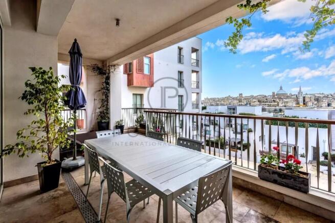 A spacious balcony with a dining table and chairs 