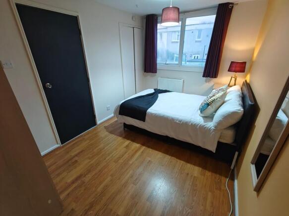 Neat double room with large window and wood flo...