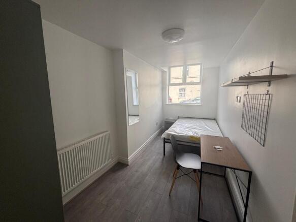 This cozy double bedroom features ample natural...