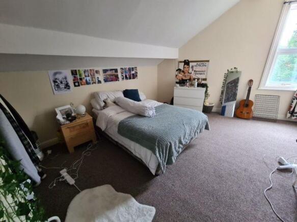 A spacious and well-lit master bedroom featurin...