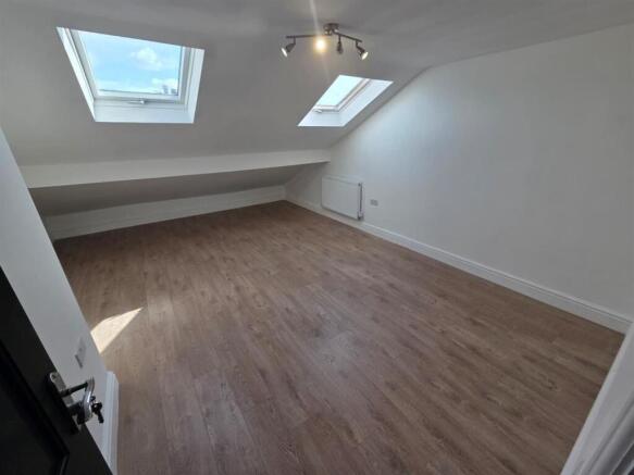 Bright attic room with stylish wood flooring...