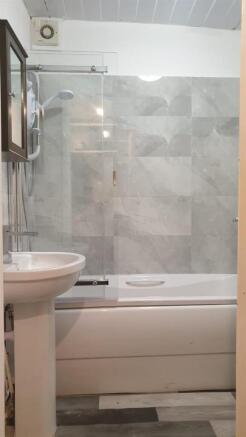 Modern bathroom with a tiled shower-bath, glass...