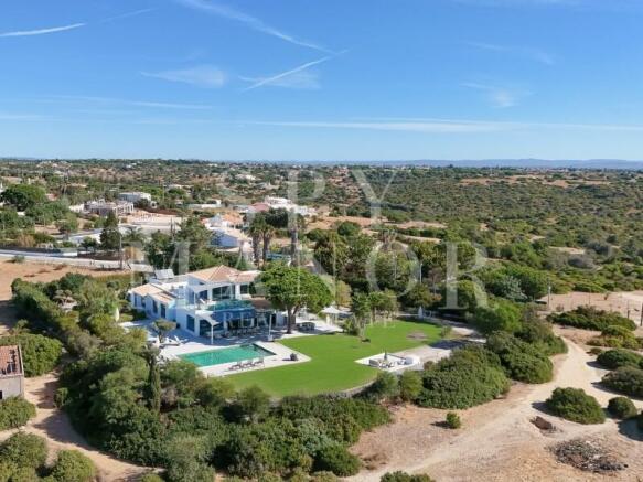 Aerial view of a detached villa with swimming pool and large plot in Caramujeira.