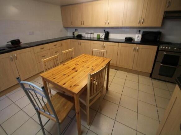 Modern galley-style kitchen with light wood cab...