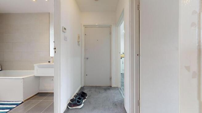 Bright, neutral hallway with soft carpeting, a ...