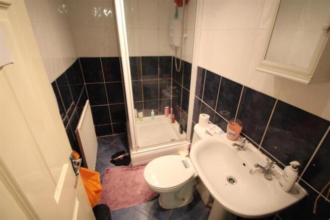 A compact bathroom featuring a shower cubicle, ...
