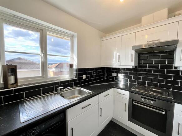 Bright modern kitchen with stylish black tiles...