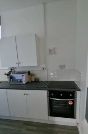 A neat and functional kitchen featuring white c...