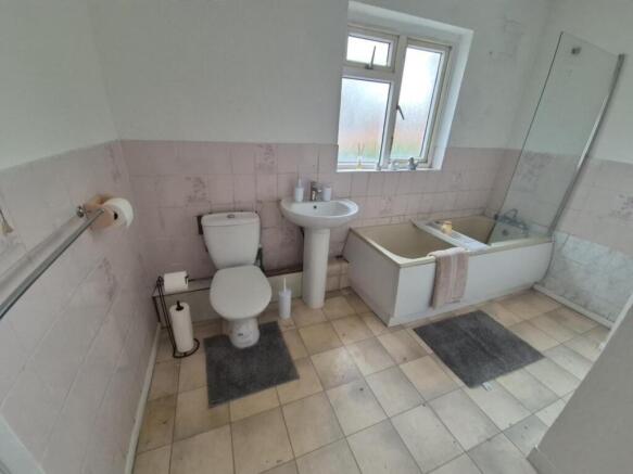 Bright, spacious bathroom with bathtub and show...