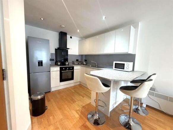 Modern kitchen with breakfast bar and sleek uni...
