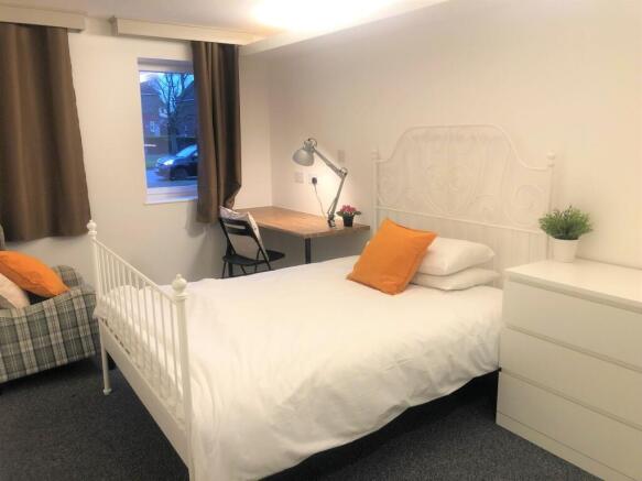 A bright and cozy double bedroom featuring a wh...