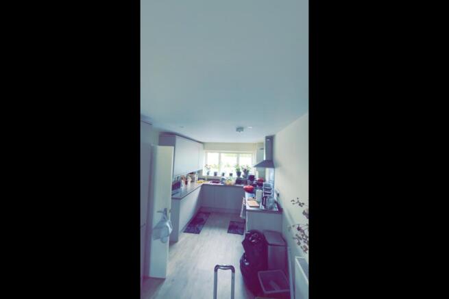 Bright galley-style kitchen with a window above...