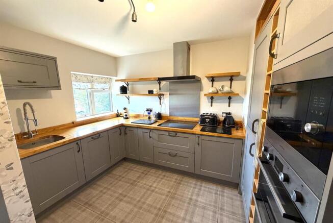 Modern kitchen with stylish grey units and wood...