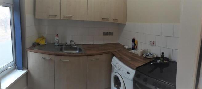 Well-presented compact kitchen with natural lig...