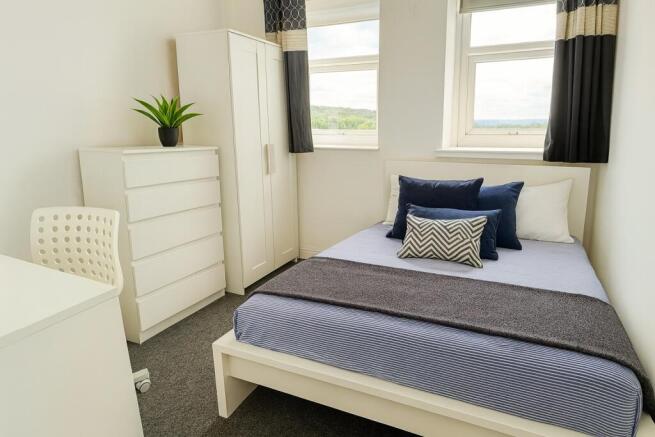 A bright and clean double bedroom featuring a w...