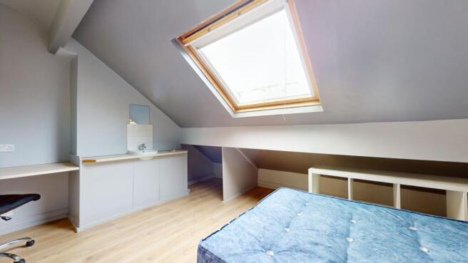 Bright and welcoming bedroom with a large skyli...
