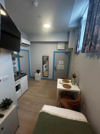 Compact studio room with a neat kitchenette, di...