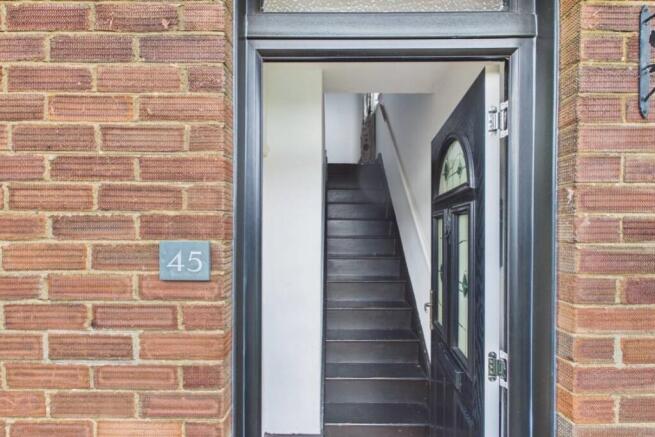 Wooden stairs and a tiled floor in the entrance ha