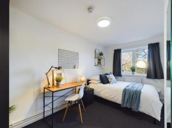 A bright and inviting double bedroom with a sty...