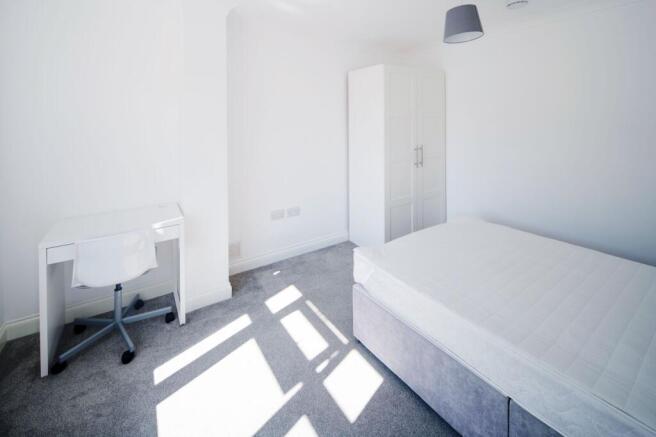 Bright, minimalist double bedroom with a large ...