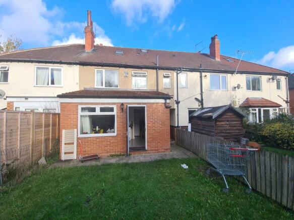 A spacious and well-maintained garden area behi...