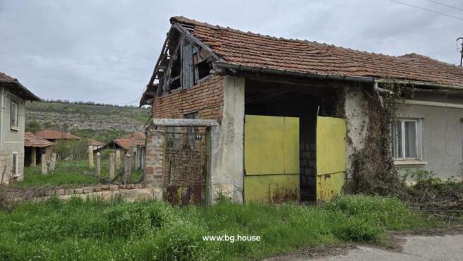 Barn structure with yellow metal double doors and brick walls adjacent to the house
