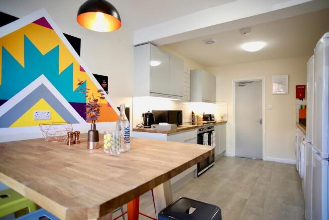 Bright, modern kitchen with a large wooden brea...