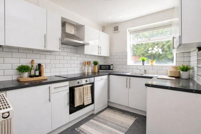Bright modern kitchen with integrated appliance...