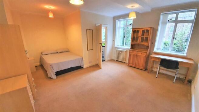 Spacious master bedroom with study desk and bed...